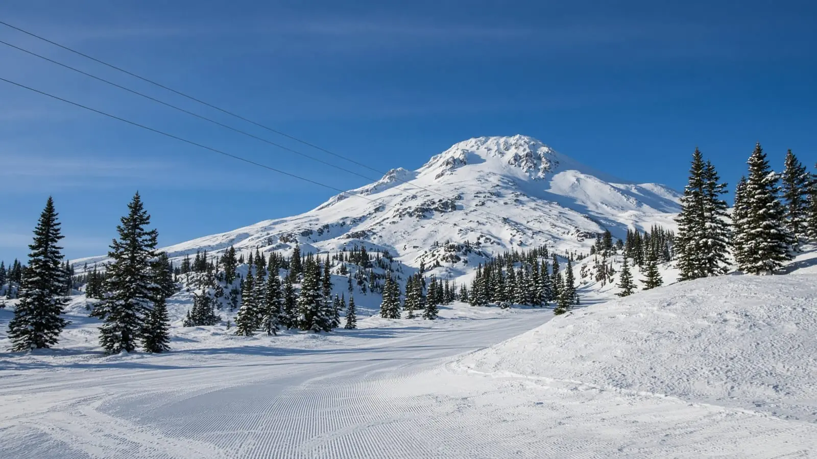 Snow-covered Cascade peak above a groomed winter run